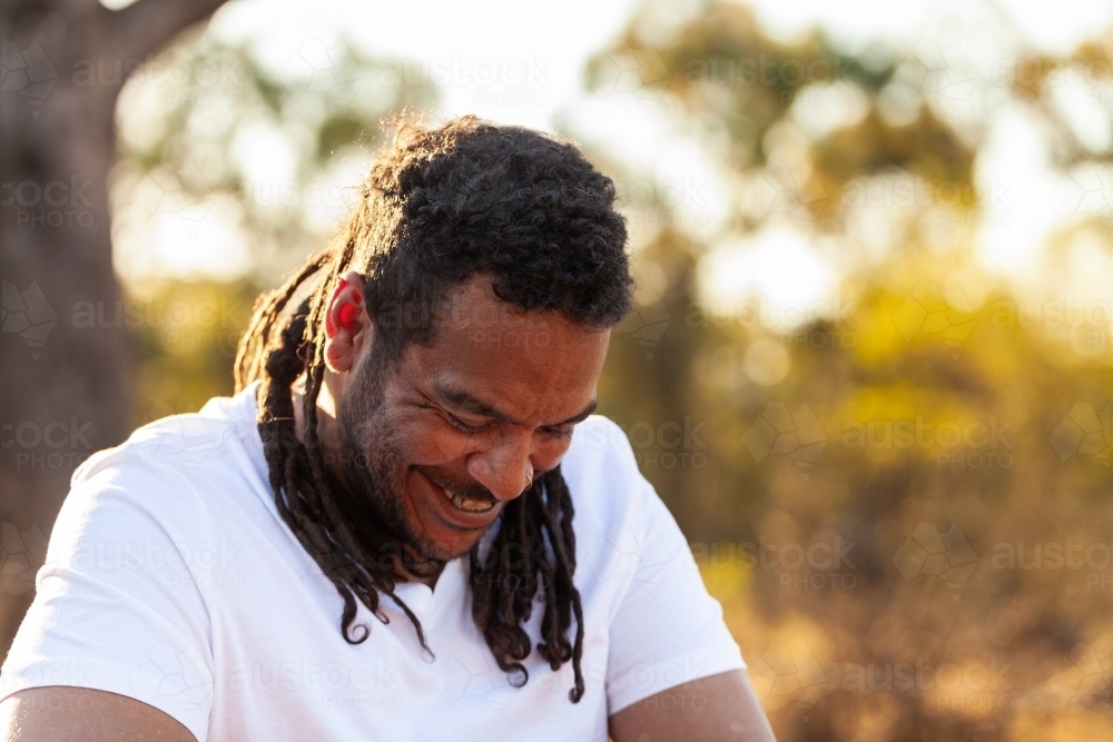 Laughing aboriginal man with copy space in country setting - Australian Stock Image