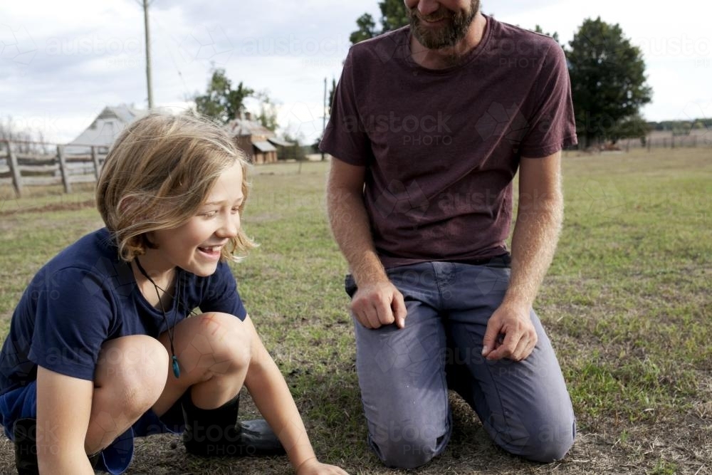 Laughing girl with father outside in paddock - Australian Stock Image