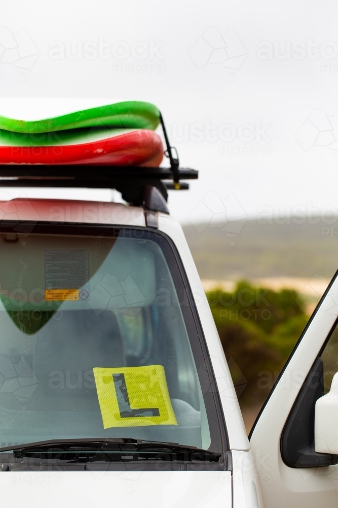 Learner Driver's L plate on vehicle with surfboards on roof - Australian Stock Image