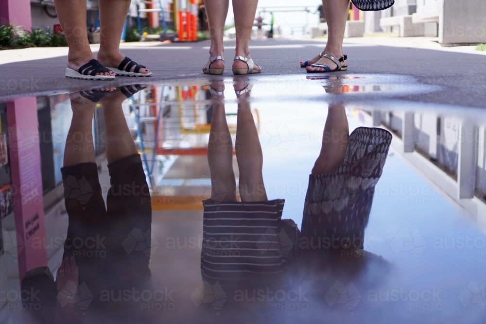 Leg reflections in a puddle of water - Australian Stock Image