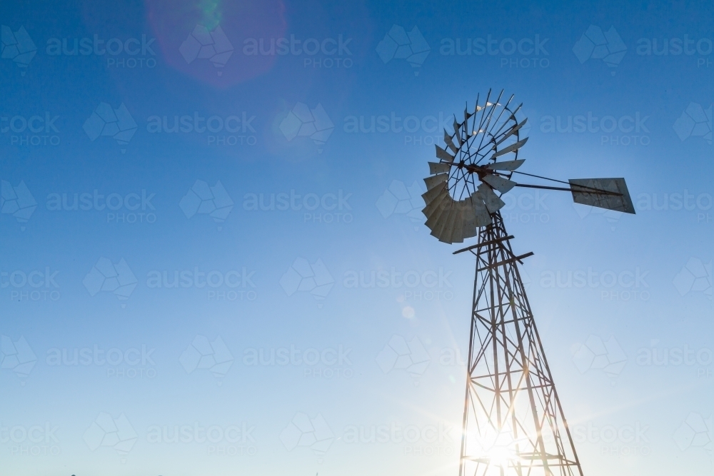 Lens flare and windmill with blue sky copy space - Australian Stock Image