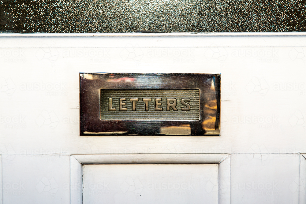Letterbox opening in white front door. - Australian Stock Image