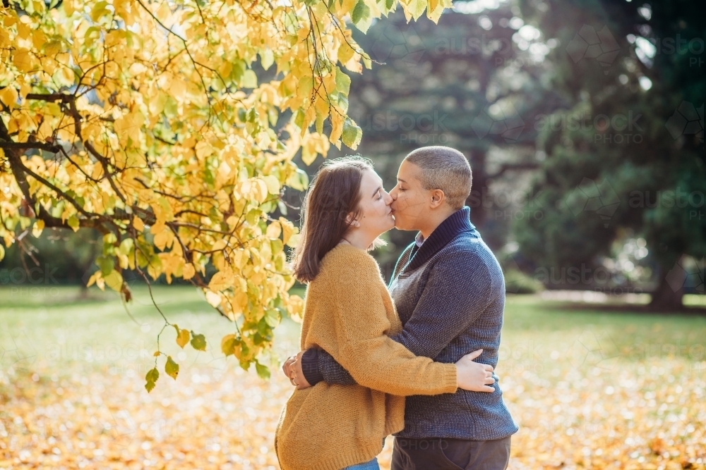 lgbtqi couple kissing near the autumn tree - Australian Stock Image