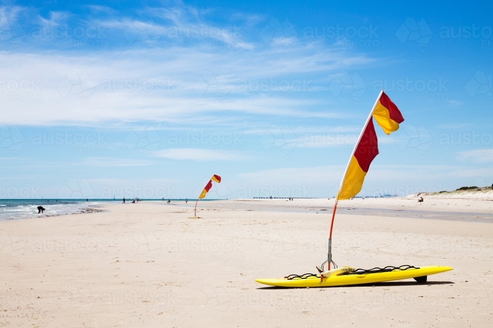 Life saver flags on sandy beach horizontal - Australian Stock Image