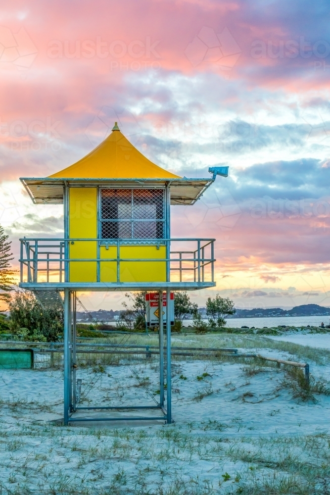 Lifeguard tower on sandy beach against colourful sky - Australian Stock Image