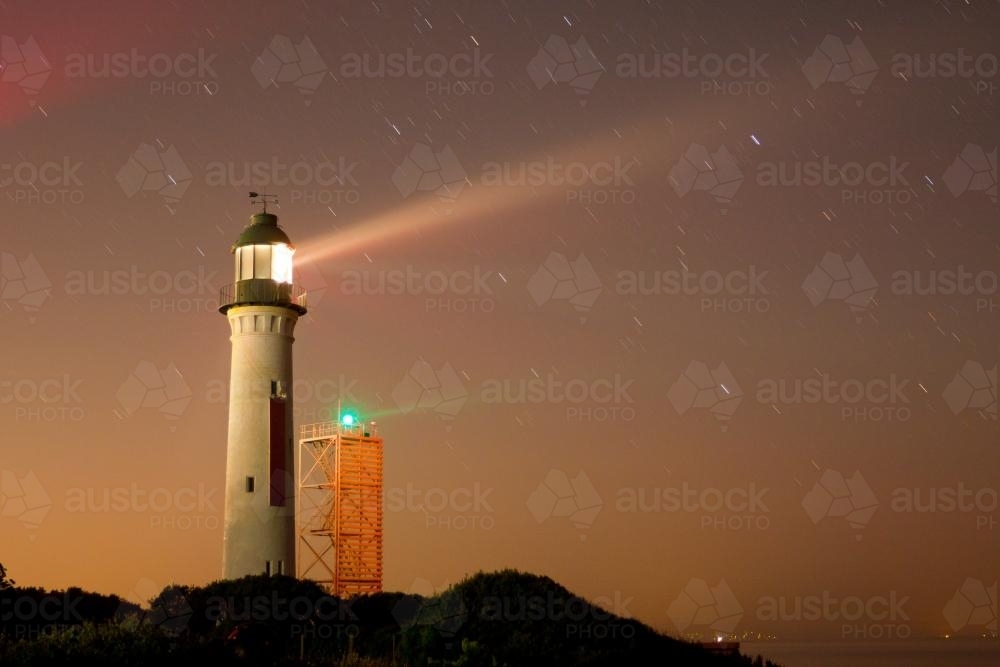 Light beams from a lighthouse at night - Australian Stock Image