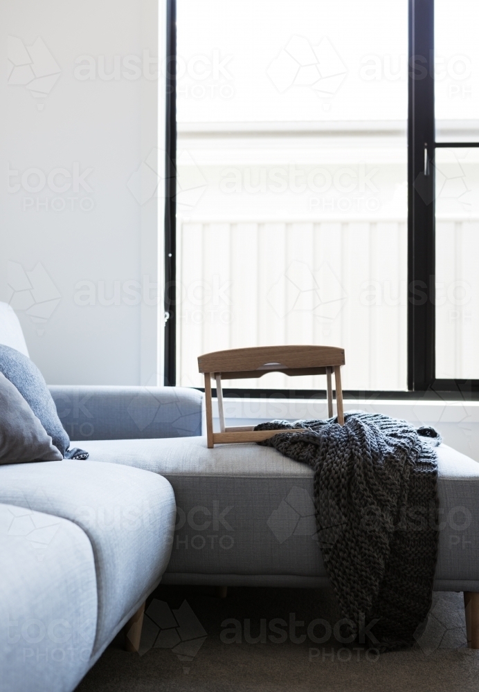 Light blue sofa with tray table and throw rug - Australian Stock Image