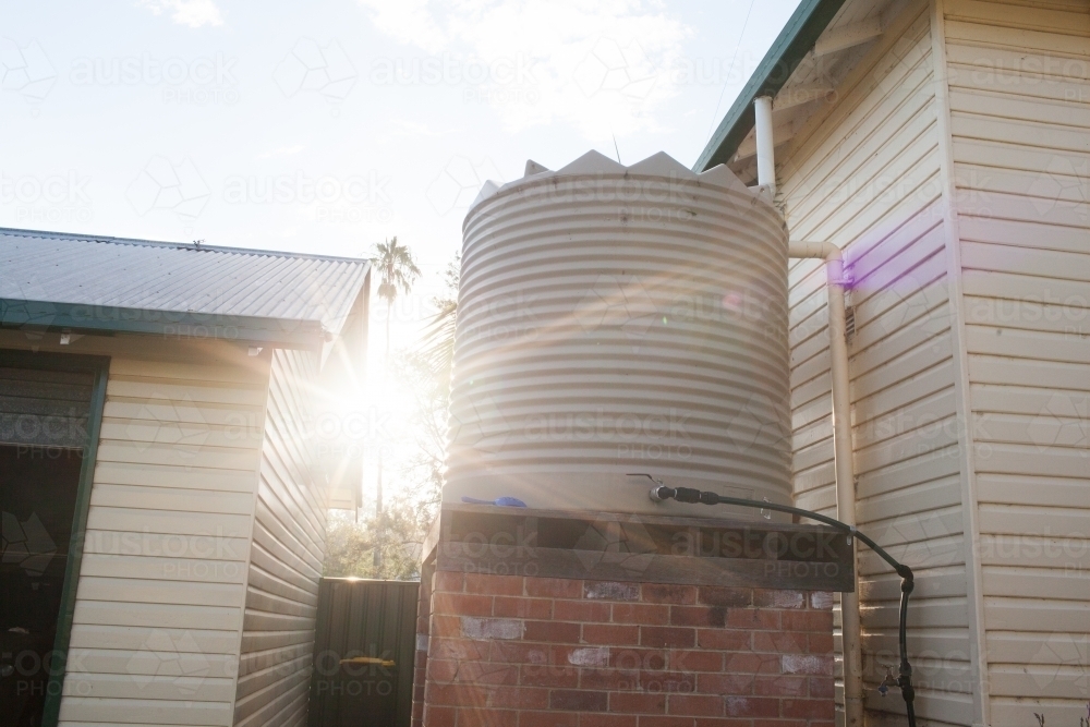 Light flare on a backyard water tank - Australian Stock Image