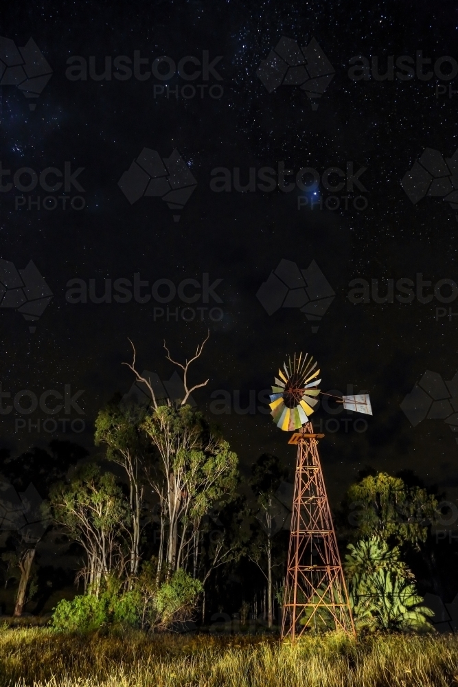 Light painting of rural windmill at night with stars. - Australian Stock Image