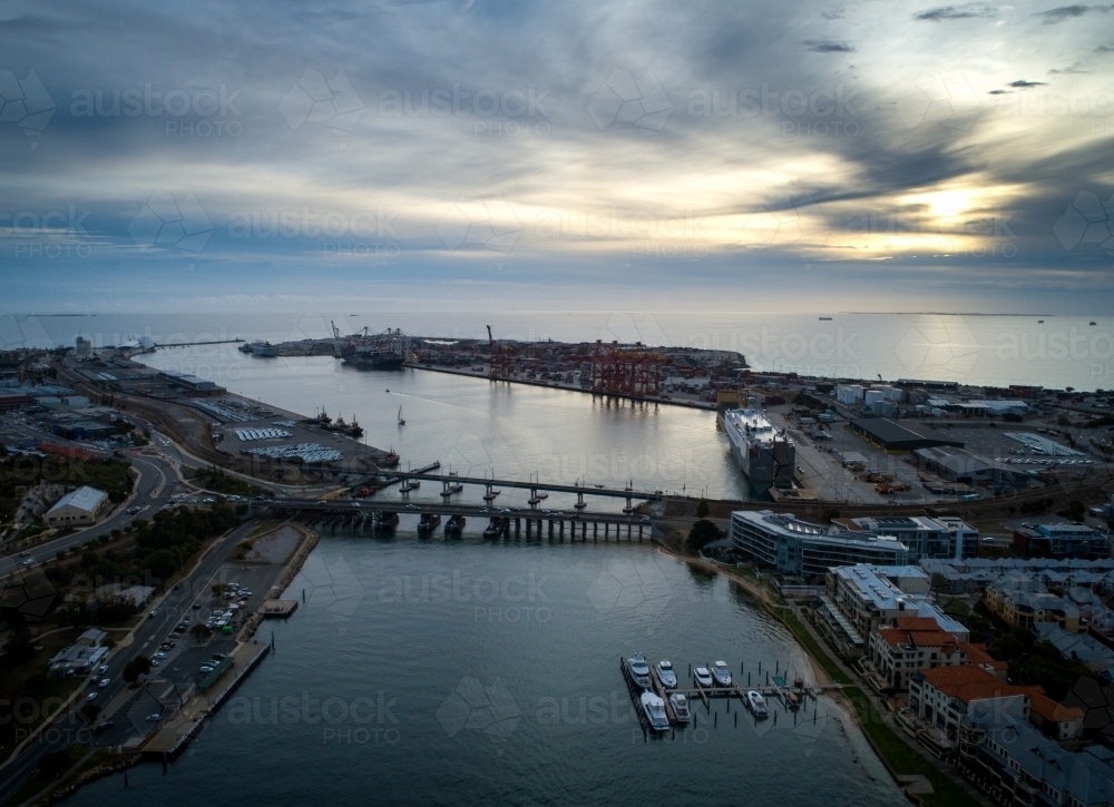 Light pierces cloud in an aerial view over a port - Australian Stock Image