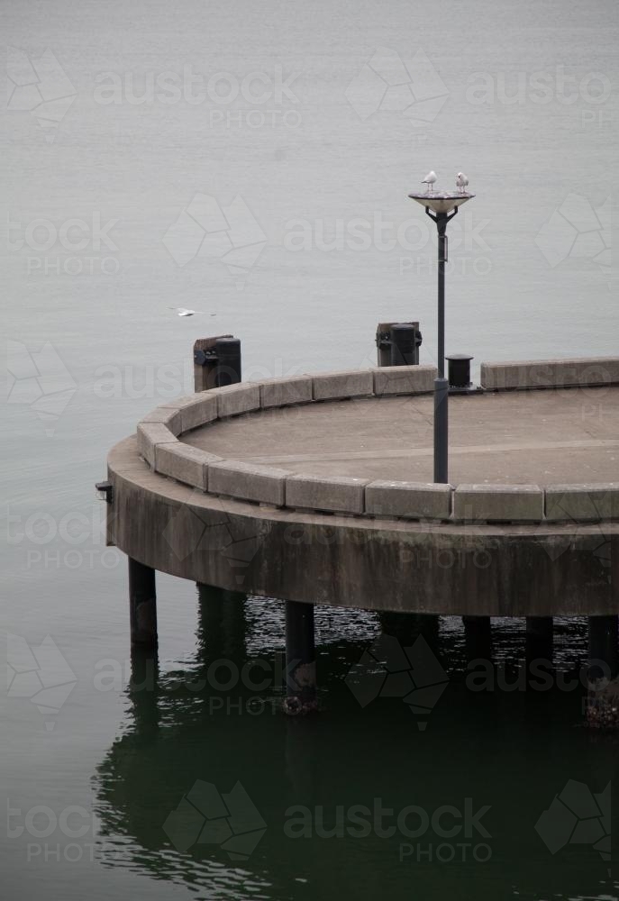 Light post on concrete ferry wharf in Newcastle on overcast day - Australian Stock Image