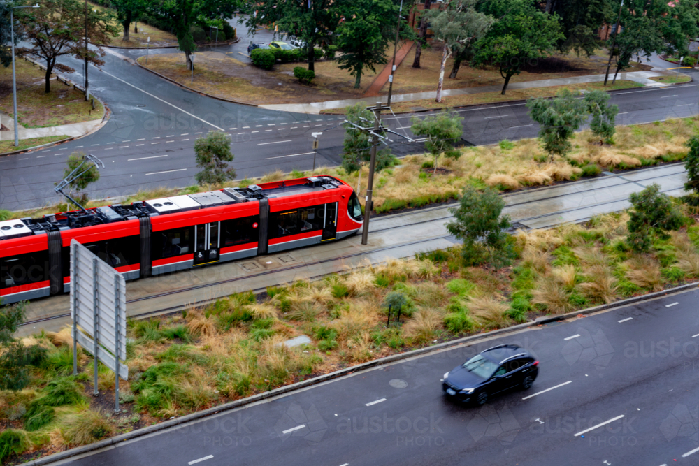 Image of light rail track in Canberra with a red train from above ...