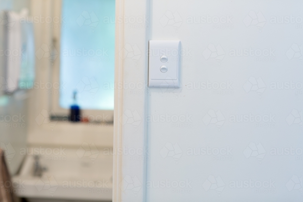 Image of Light switch on wall outside bathroom Austockphoto