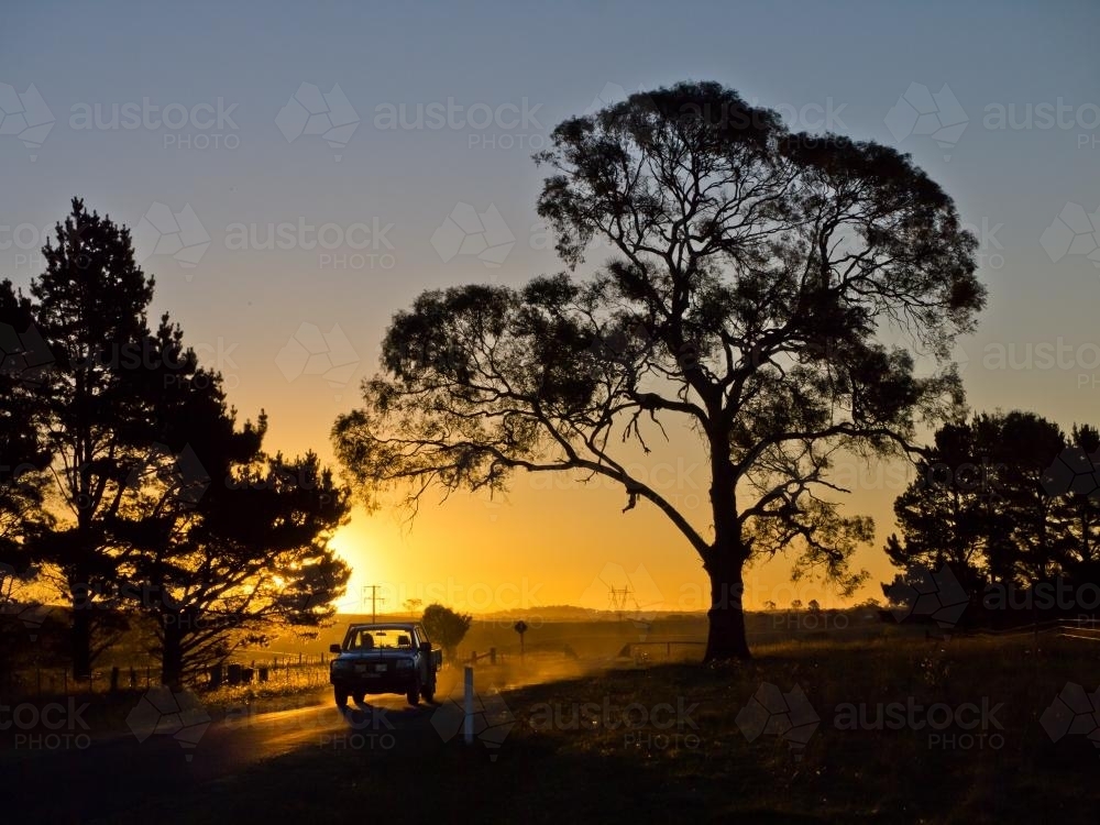 Light truck "heading home" silhouetted against the sunset - Australian Stock Image