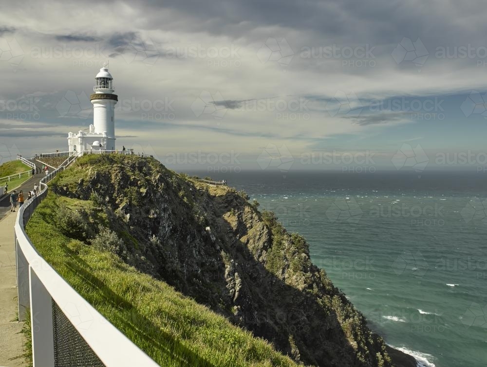 Lighthouse on headland against stormy sky - Australian Stock Image