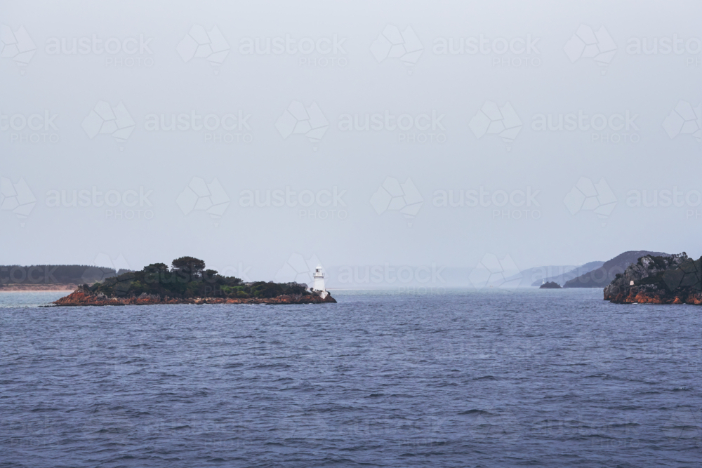 Lighthouse on island in harbour entrance, Tasmania - Australian Stock Image