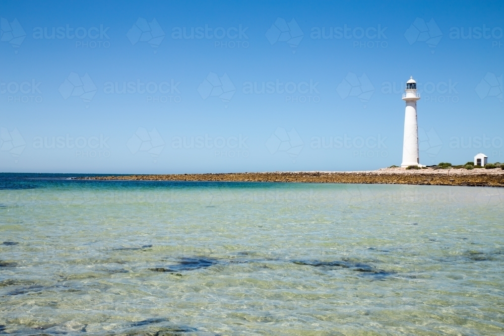 lighthouse on low rocky point - Australian Stock Image