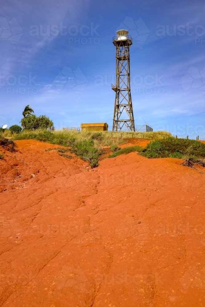 Lighthouse tower surrounded by red dirt and blue sky - Australian Stock Image