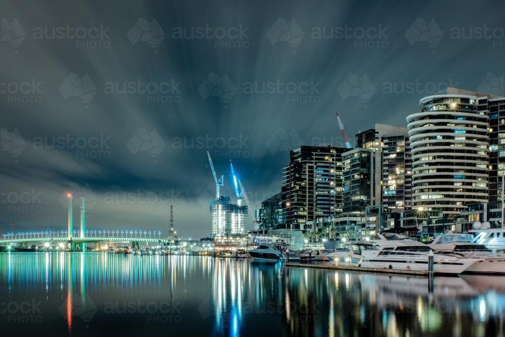Lights of docklands and Bolte Bridge reflected in water at night - Australian Stock Image