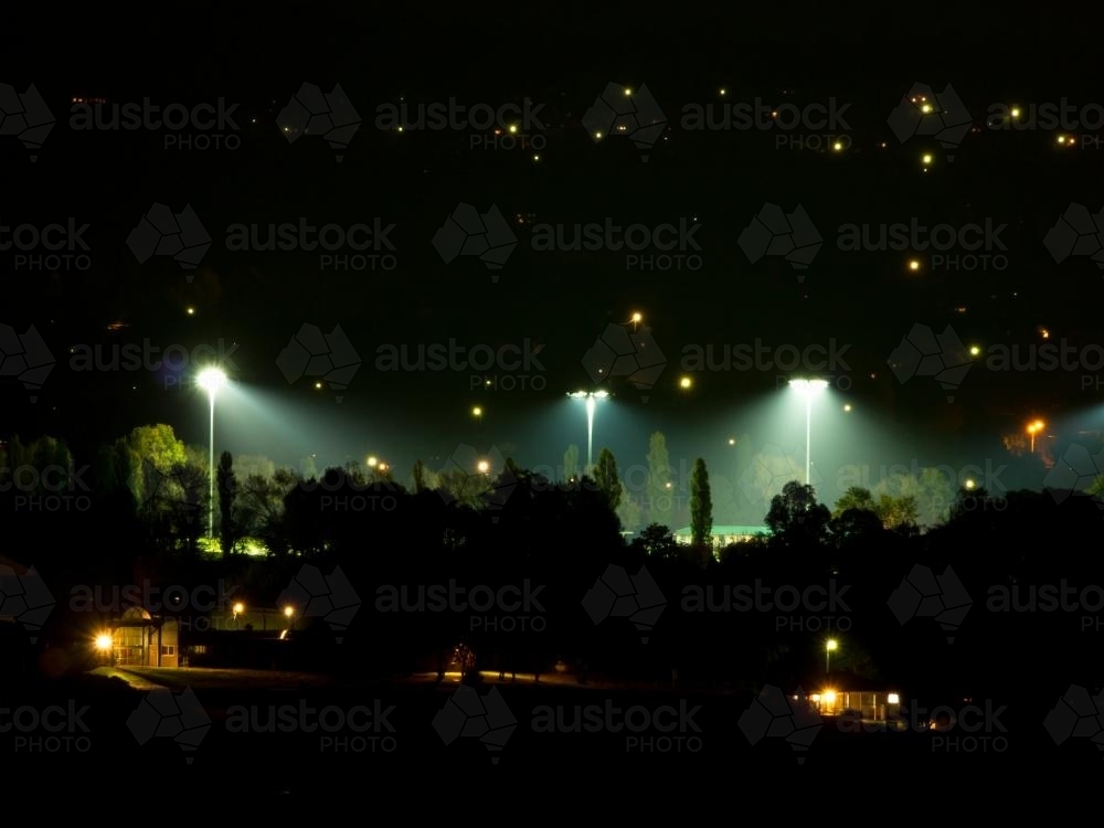 Lights on a sports oval at night in a smoky environment - Australian Stock Image