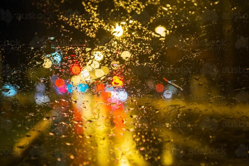 Image of Lights shining through a window on a rainy night - Austockphoto