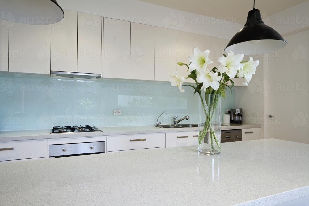 Lily flowers on white kitchen island bench top - Australian Stock Image