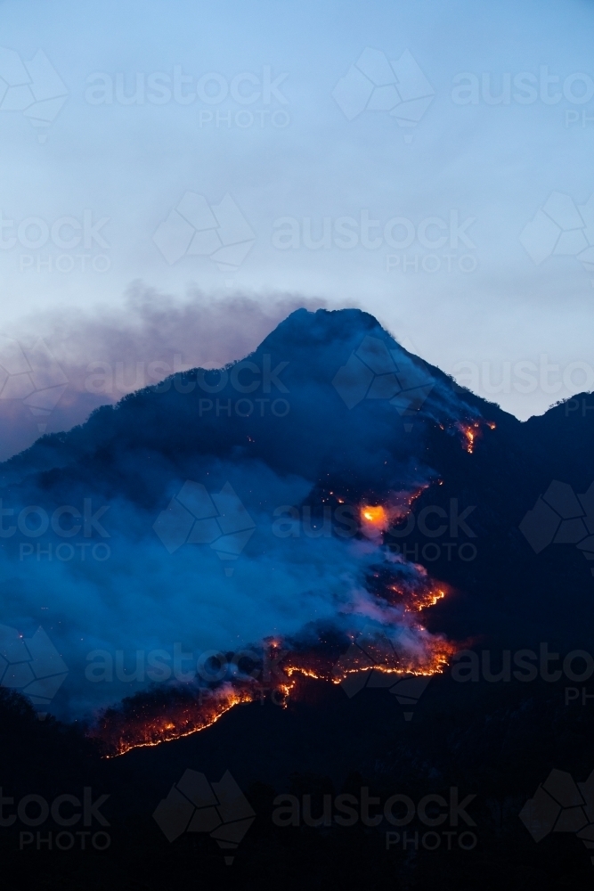 Line of fire crossing a mountain range at dusk - Australian Stock Image