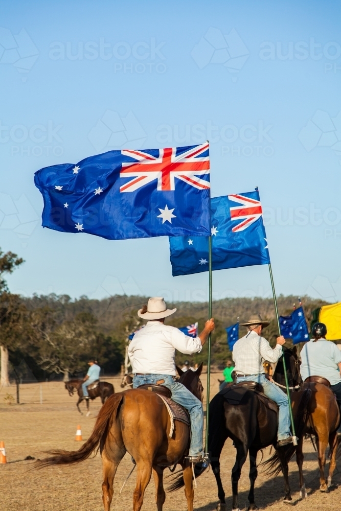Line of horse riders with Australian flags outside - Australian Stock Image