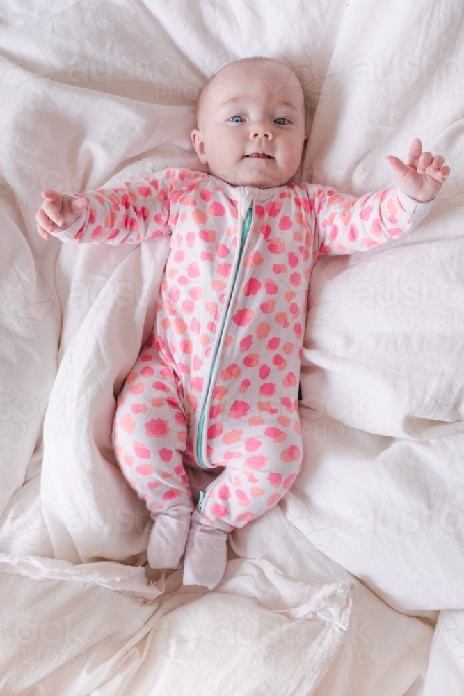 Little baby girl lying on the bed . - Australian Stock Image
