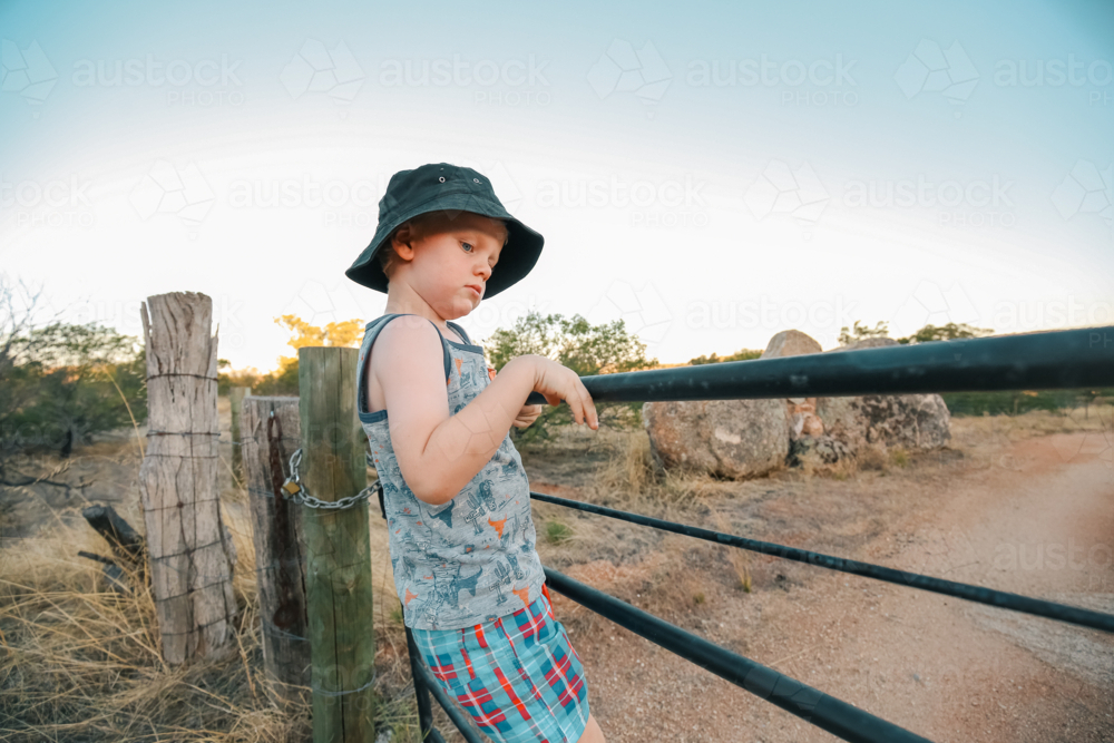 Little boy climbing rustic farm gate in rural Victoria - Australian Stock Image