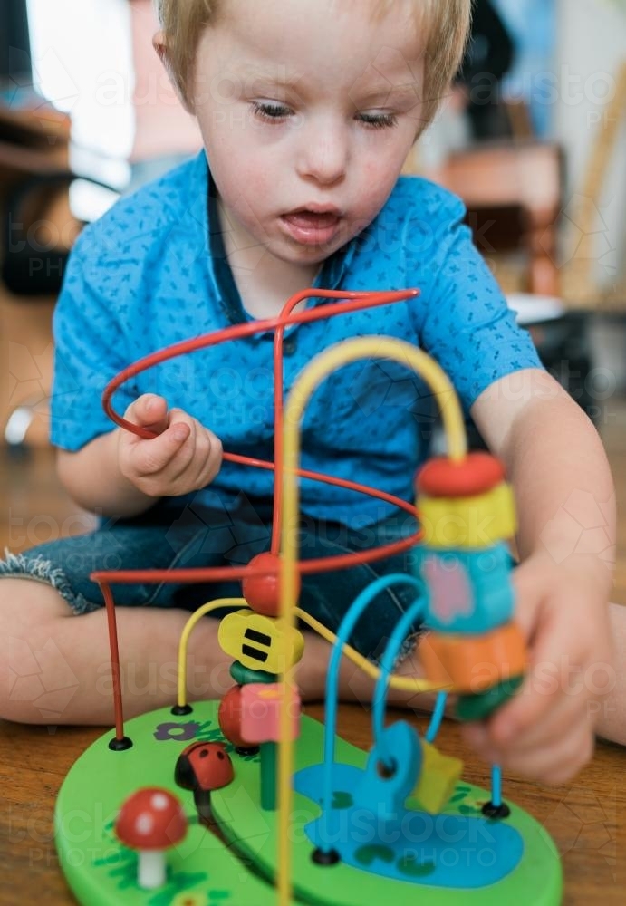Little Boy Concentrating on a Toy - Australian Stock Image