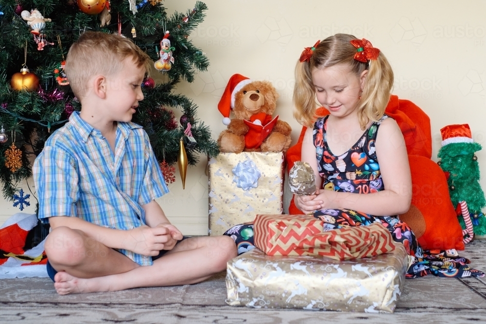Little boy giving his sister a gift on Christmas day - Australian Stock Image