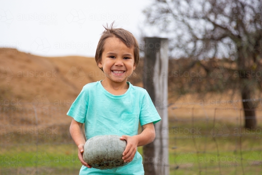 Little boy holding a pumpkin - Australian Stock Image