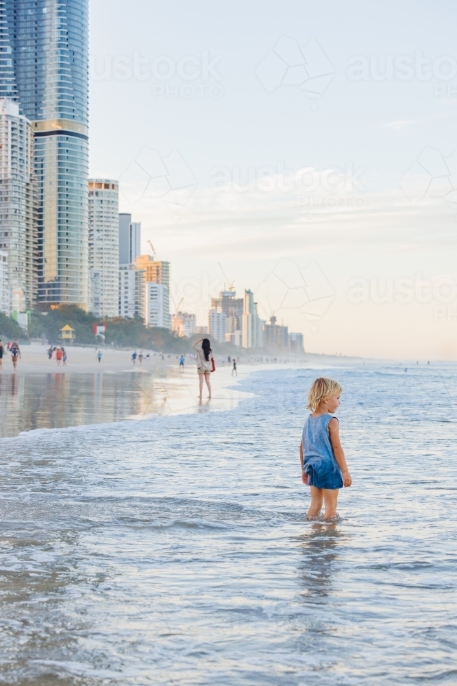 Little boy paddling in shallow water on the beach at the Gold Coast - Australian Stock Image