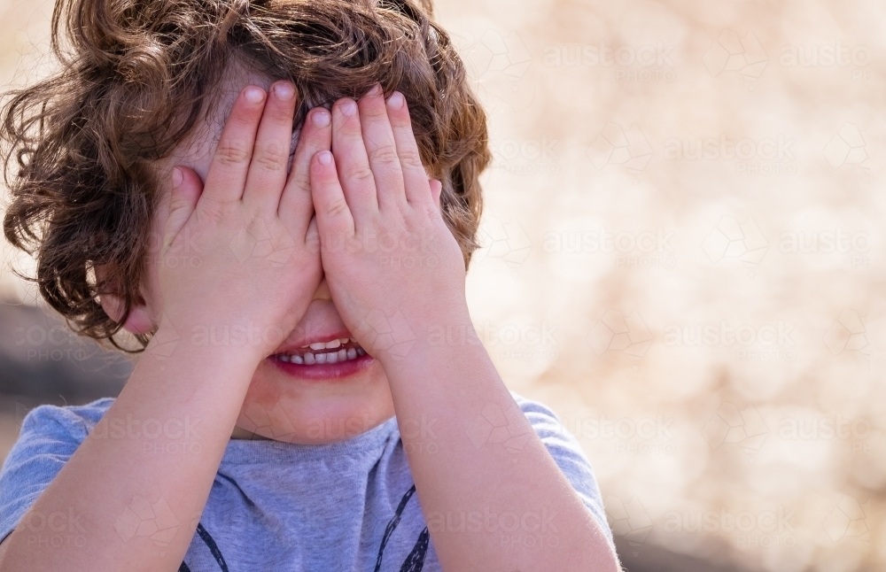 Little boy playing hide and seek - Australian Stock Image
