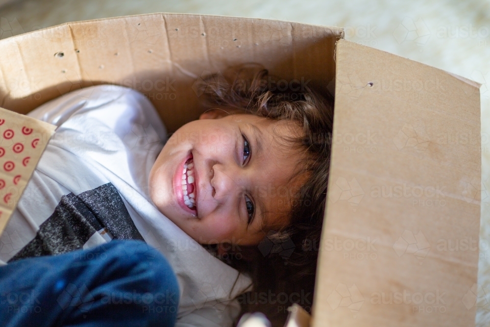 Little boy playing in a cardboard box - Australian Stock Image