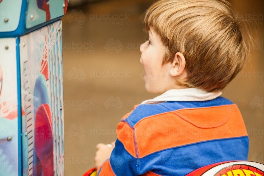 Little boy playing on kiddie ride at the supermarket - Australian Stock Image