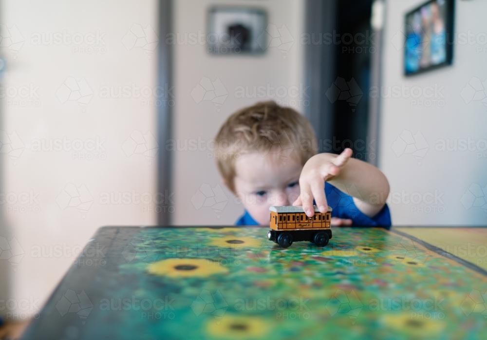 Little Boy playing with a Toy Train - Australian Stock Image