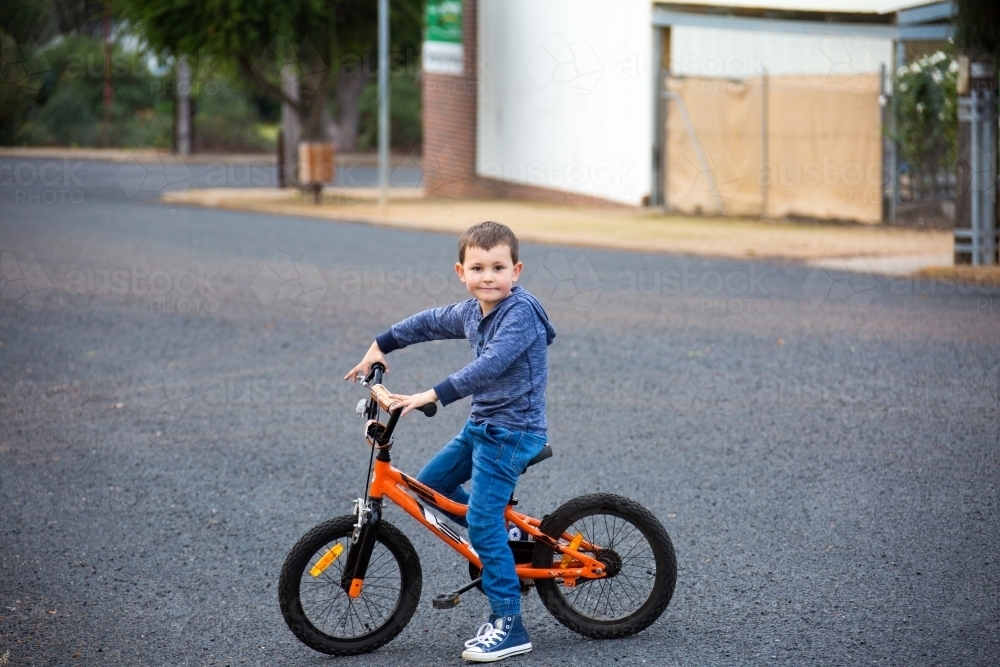 Little boy riding his bicycle on the street - Australian Stock Image