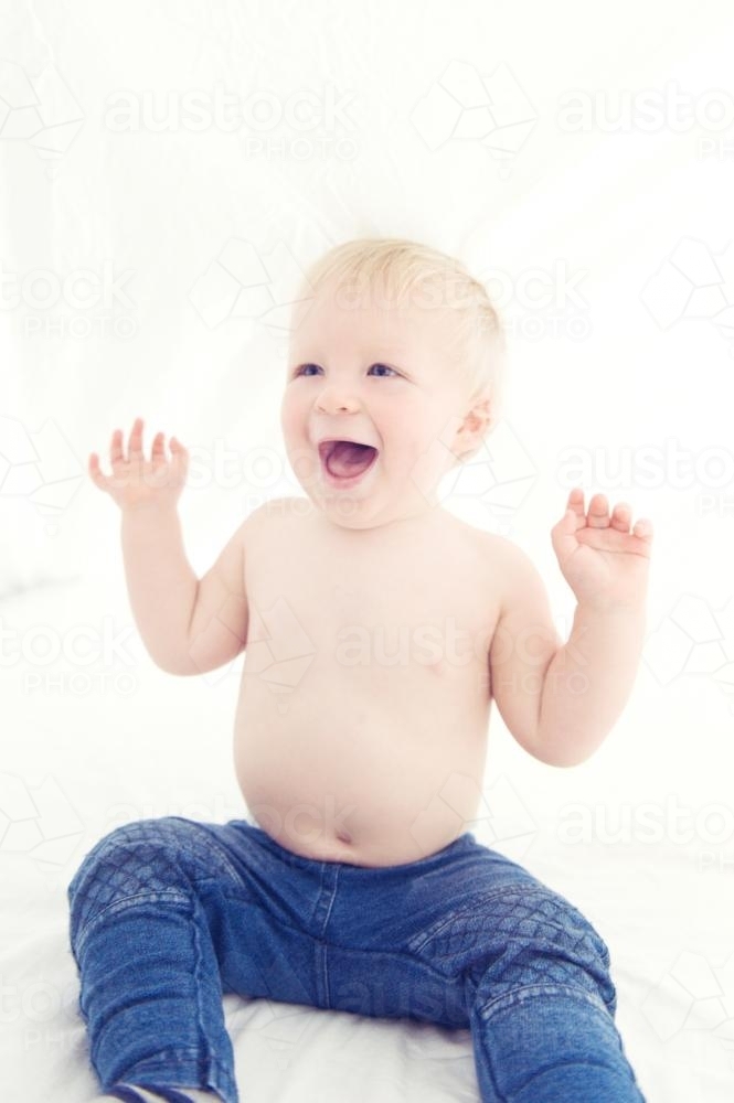 Little Boy under the sheets laughing - Australian Stock Image