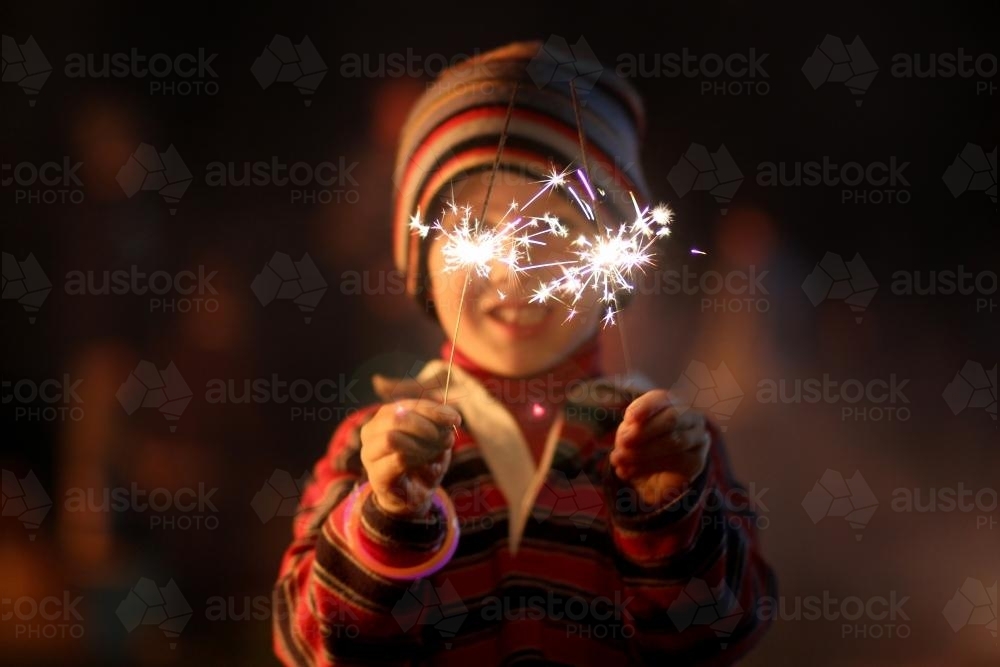 Little boy waving sparklers on a bonfire night - Australian Stock Image
