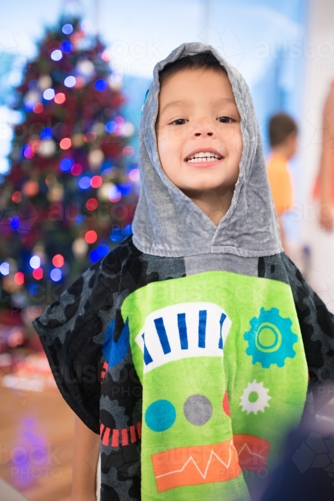 Little boy wearing a hooded towel he received for Christmas - Australian Stock Image