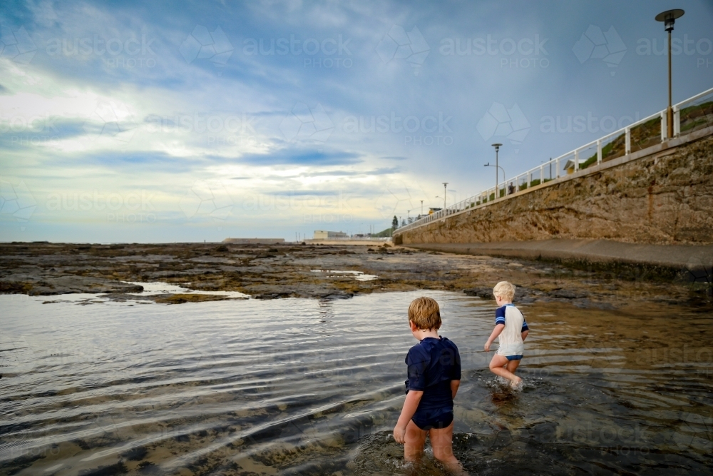 Little boys paddling in shallow water at Nobby's Beach, Newcastle - Australian Stock Image