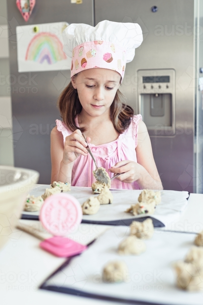 little girl baking at home in the kitchen - Australian Stock Image