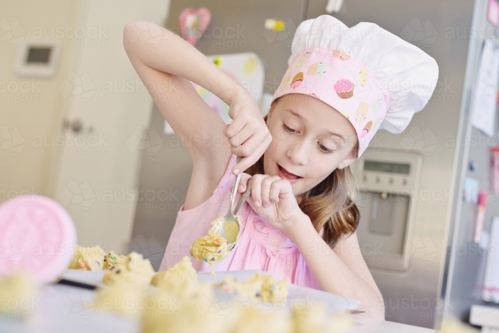 little girl baking at home in the kitchen - Australian Stock Image