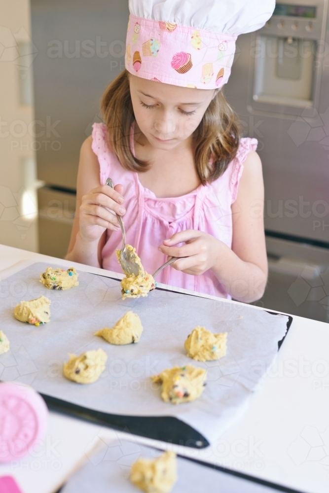 little girl baking at home in the kitchen - Australian Stock Image
