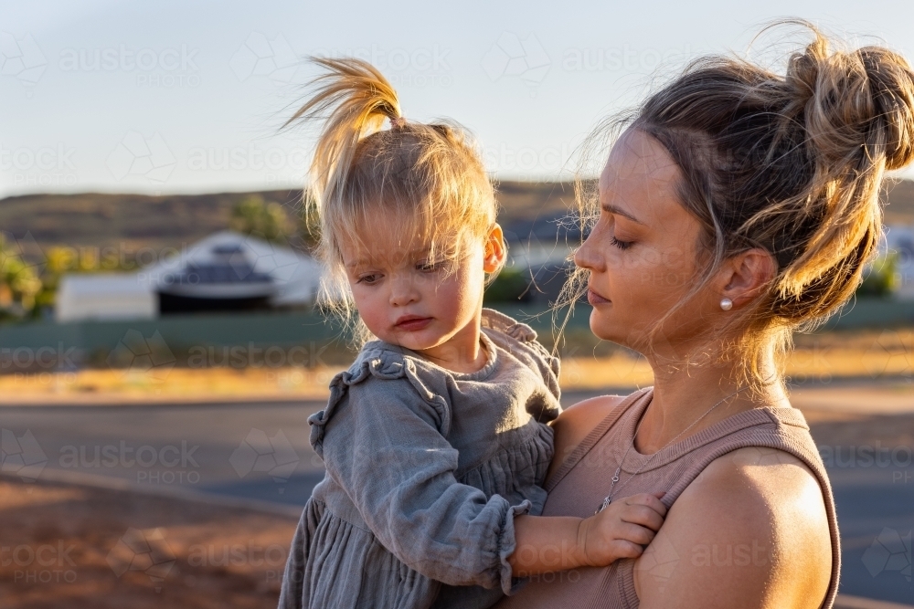 little girl being carried by her mum - Australian Stock Image