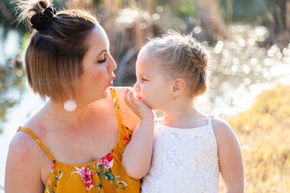 Little girl blowing her mum kisses - Australian Stock Image