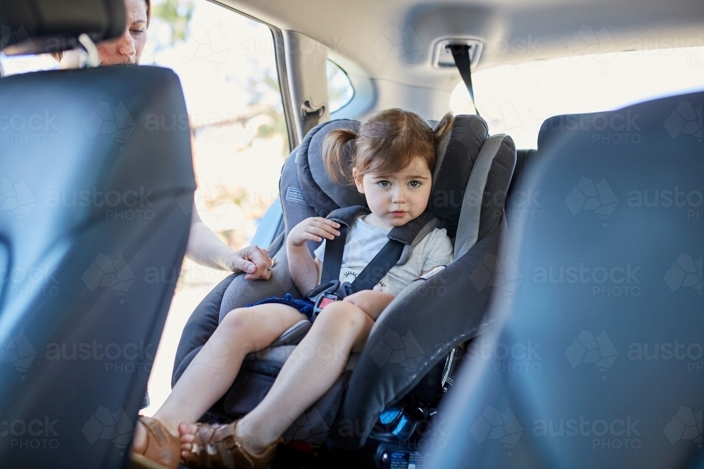 Little girl clicked into car seat - Australian Stock Image