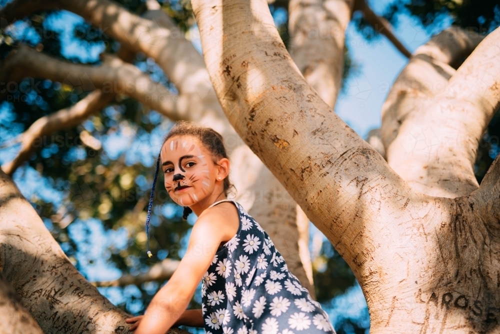 Little girl climbing a tree - Australian Stock Image